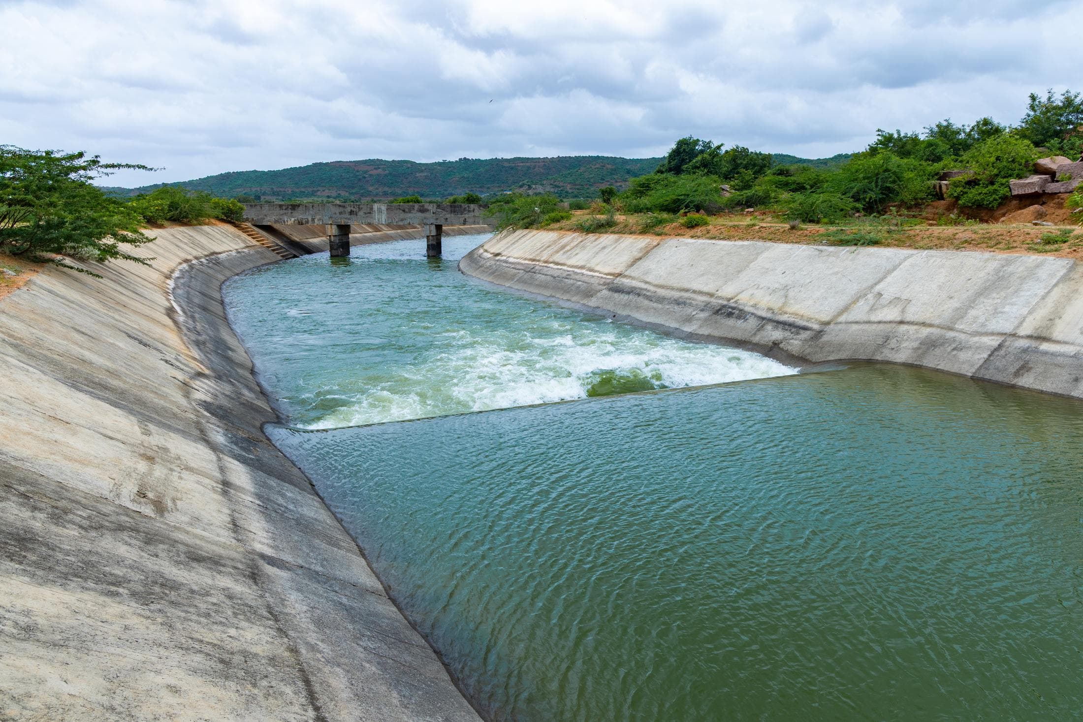 Concrete-lined irrigation canal carrying water at full flow